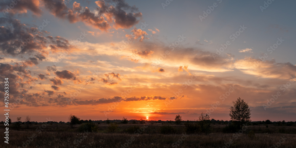 Beautiful sunset sky in countryside. Dramatic colorful clouds in the sky