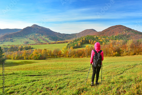 Woman backpacker on hiking trail in the mountains in autumn sunny day, Low Beskids (Beskid Niski)