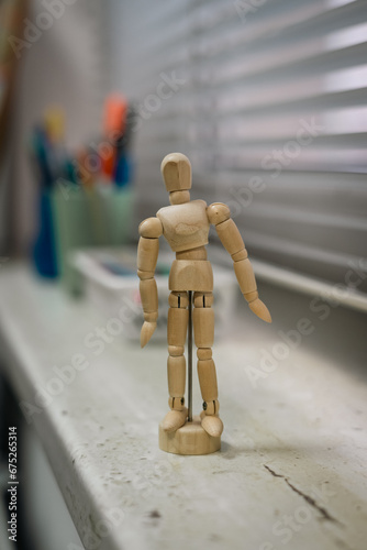wooden mannequin in the office near the window 