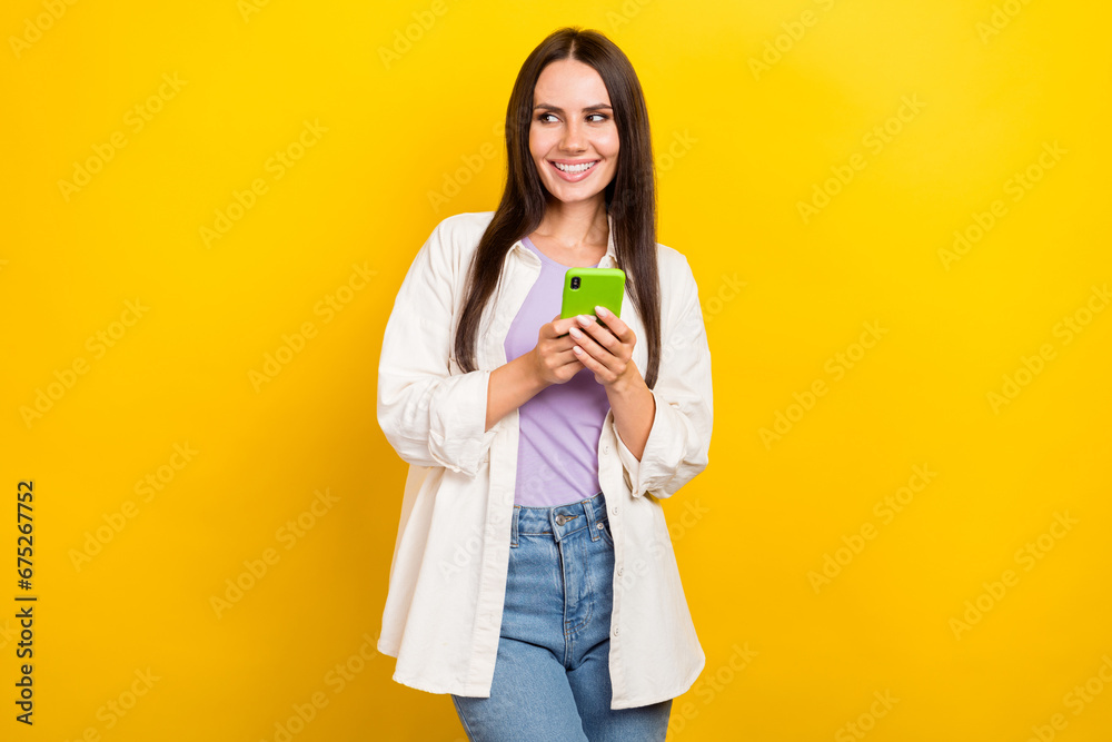 Photo of lovely woman with long hairstyle dressed white jacket hold smartphone look empty space offer isolated on yellow color background Photo of lovely woman with long hairstyle dressed white jacket hold smartphone look empty space offer isolated on yellow color background