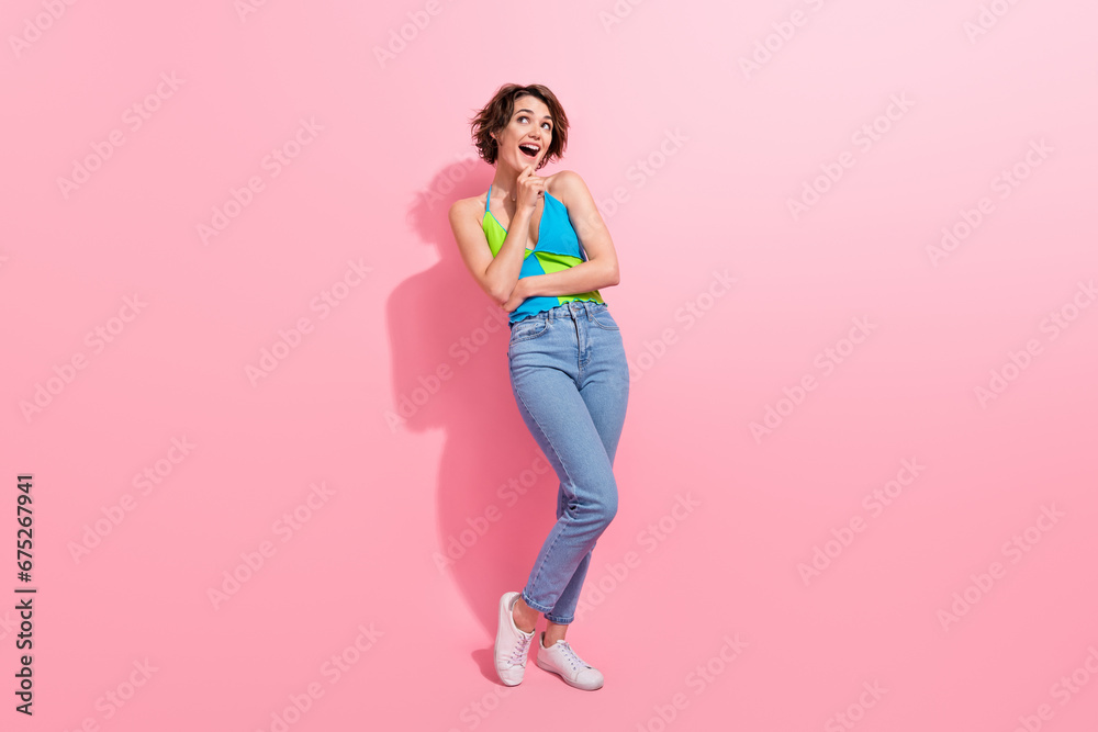 Full length image of funny youth lady touch chin surprised looking copyspace excited choose new swimwear isolated on pink color background Full length image of funny youth lady touch chin surprised looking copyspace excited choose new swimwear isolated on pink color background