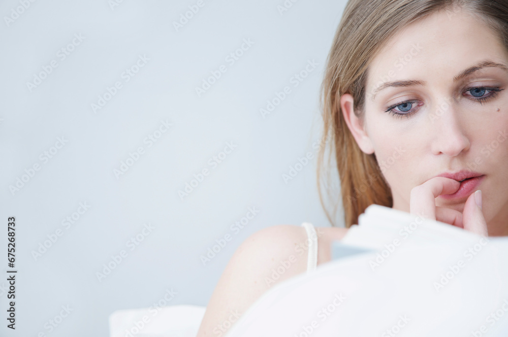 Woman reading in bed with finger on lips
Woman reading in bed with finger on lips