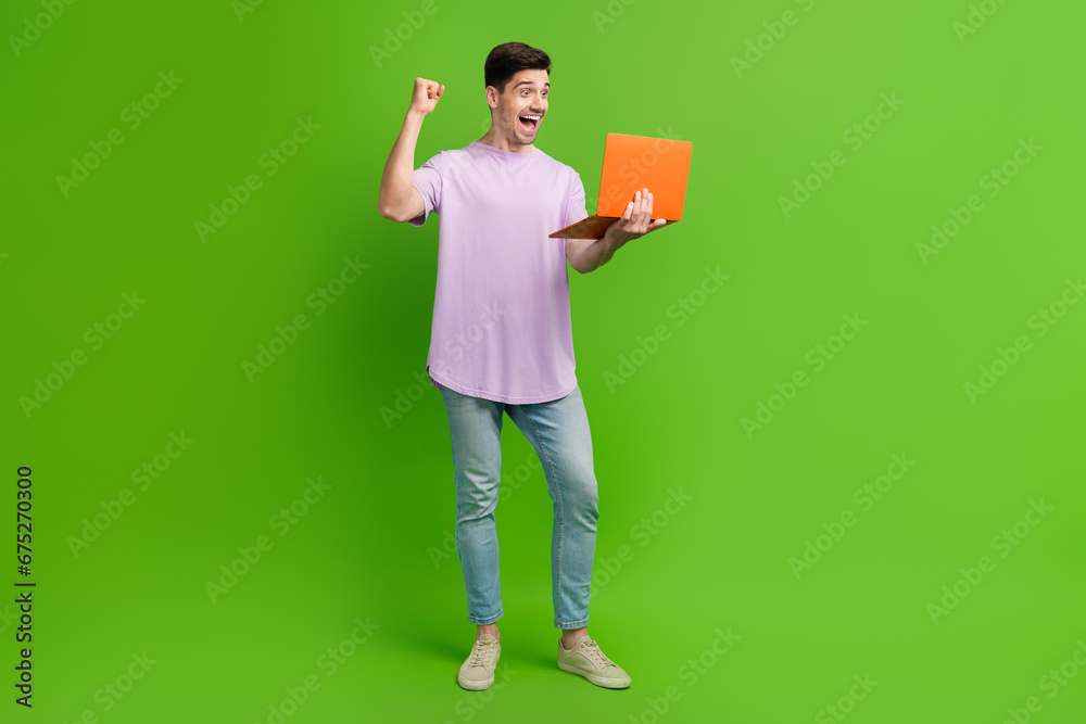 Full length photo of positive glad attractive man dressed stylish clothes watching movie shouting yes isolated on green color background Full length photo of positive glad attractive man dressed stylish clothes watching movie shouting yes isolated on green color background