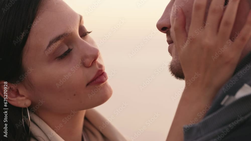 Closeup of a young woman caressing her boyfriend's face, sharing a tender kiss, expressing deep affection and love Closeup of a young woman caressing her boyfriend's face, sharing a tender kiss, expressing deep affection and love