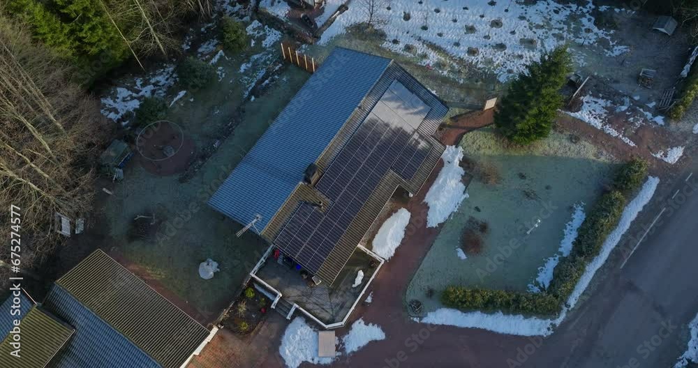 Aerial high angle, orbit shot around partly frosty solar cells, on a house roof Aerial high angle, orbit shot around partly frosty solar cells, on a house roof