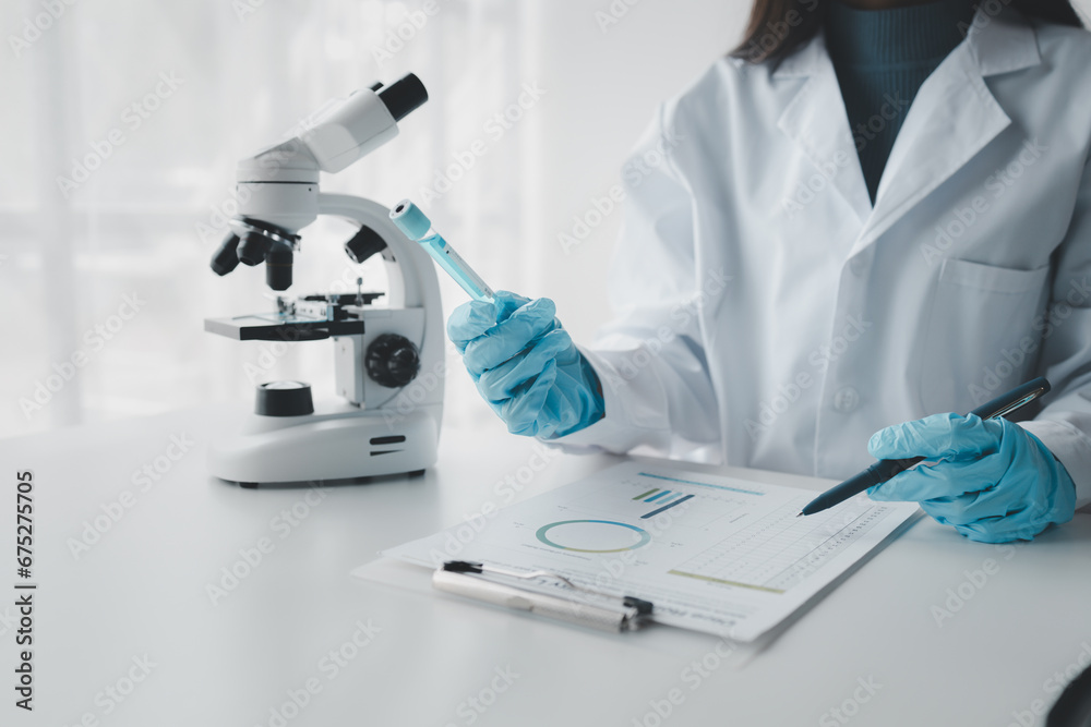 Fototapeta premium Chemist taking notes on research data, Scientist is working in the laboratory, Chemist is analyzing experimental results and taking notes in the laboratory, lab idea.