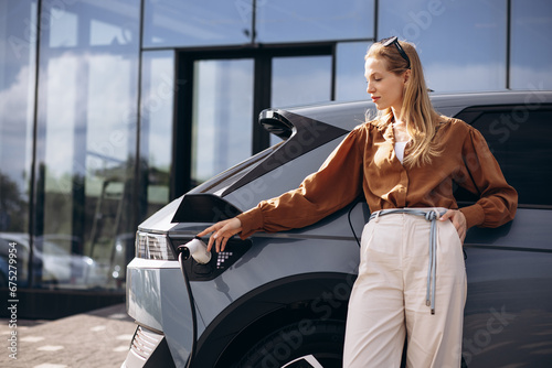 Business woman charging electric car