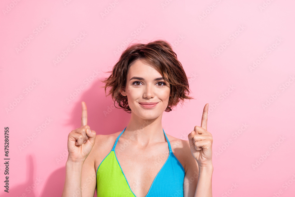 Photo portrait of attractive girl directing fingers up empty space ads wear summer top shadow isolated on pink color background Photo portrait of attractive girl directing fingers up empty space ads wear summer top shadow isolated on pink color background
