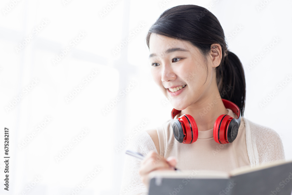 Young adult happy smiling Asian student or business woman wearing headphones talking on online chat meeting using laptop in office or campus, asian female student wear glasses learning remotely. Young adult happy smiling Asian student or business woman wearing headphones talking on online chat meeting using laptop in office or campus, asian female student wear glasses learning remotely.