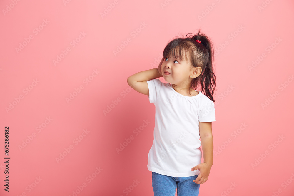 Curious little girl keeps hand near ear for eavesdropping likes gossip, wants to overhear secret information, wearing in white t shirt, tries to hear parents conversation. - obrazy, fototapety, plakaty 