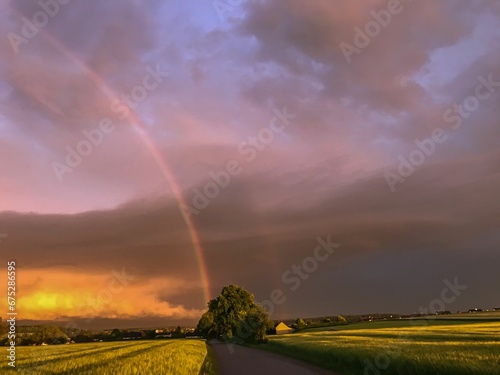 Fotografija Spectacular natural phenomenon of a double rainbow illuminating the sky above an