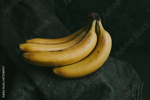 Close-up of a bunch of bananas on a dark fabric background