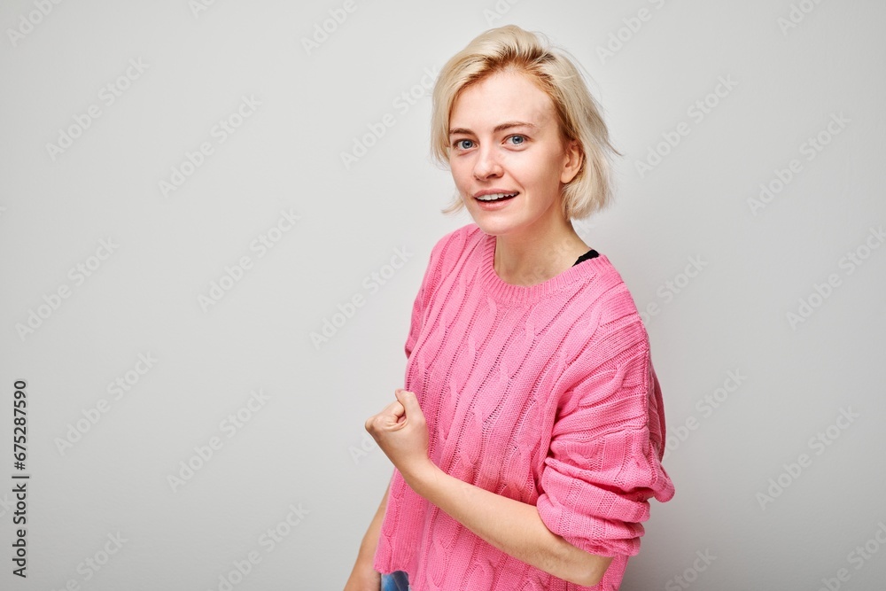 Portrait of confident young blonde woman showing biceps, demonstrating strength isolated on white studio background. Lucky winner concept Portrait of confident young blonde woman showing biceps, demonstrating strength isolated on white studio background. Lucky winner concept