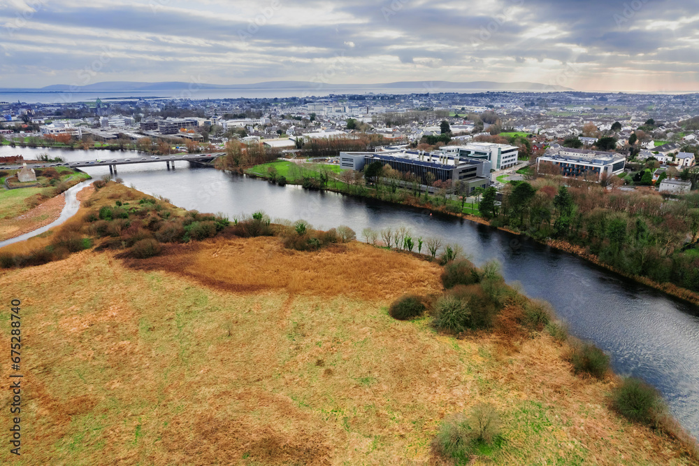 View on Corrib river and village and university buildings. Galway city, Ireland. Blue cloudy sky. Aerial view. High density area. Students accommodation.