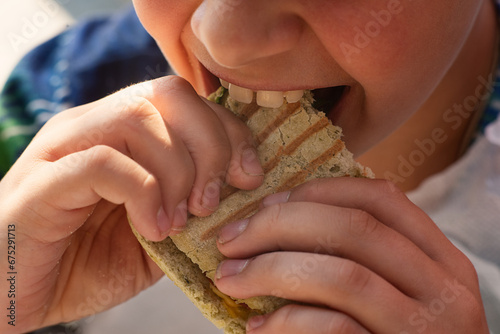 Teenage boy eating snacks close-up. Snack, sweets, street food. Intermediate meal. Mouth with teeth, tongue and saliva