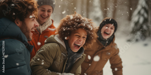 Kids and parents laughing during snowball fight in the forest