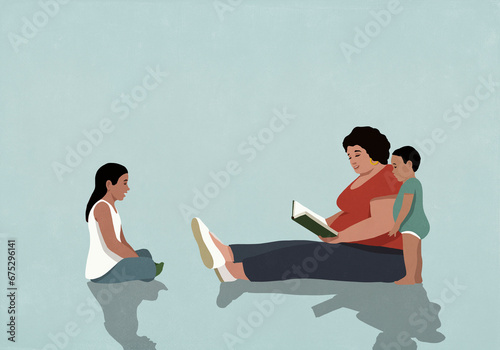 Hispanic mother sitting and reading book to daughter and baby son
 photo