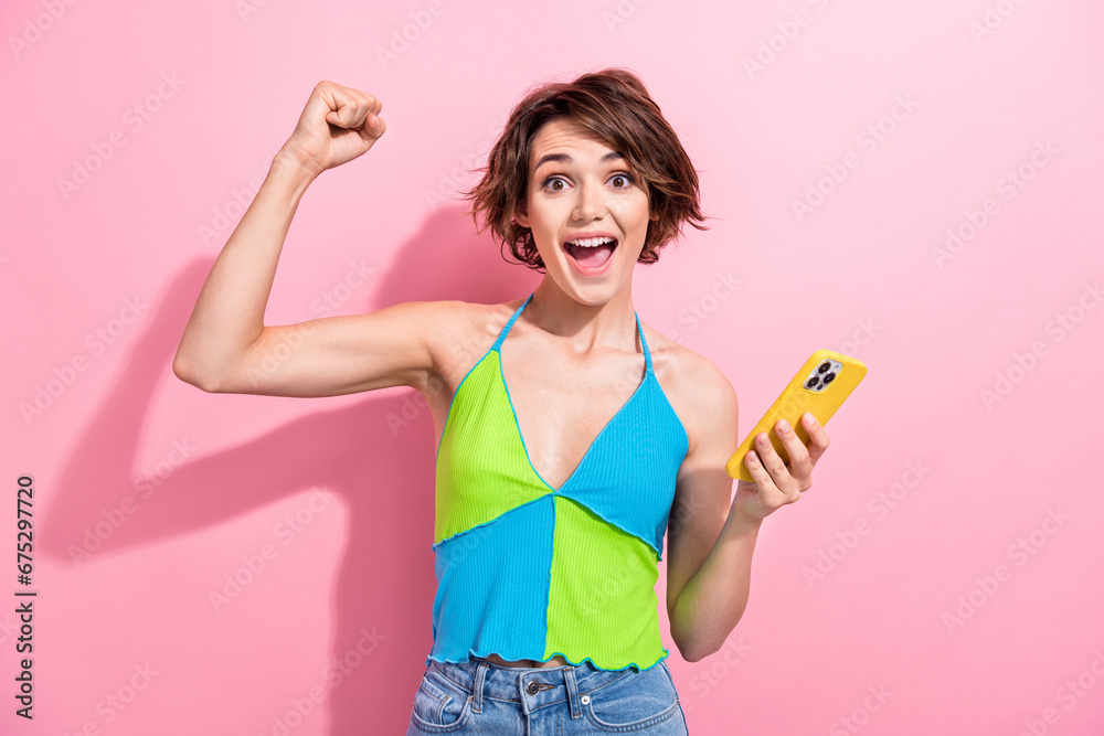 Photo of adorable lucky girl dressed blue green singlet winning game apple samsung iphone modern gadget isolated pink color background Photo of adorable lucky girl dressed blue green singlet winning game apple samsung iphone modern gadget isolated pink color background