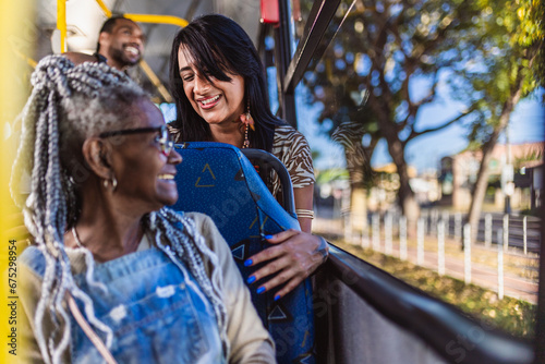 Mulher senior negra conversando com a garota do assento atras do seu no onibus. photo