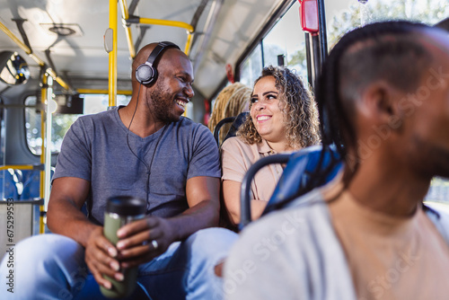 Multiracial couple smiling sitting in the bus.