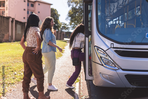 Foto Grupo multiracial de mulheres entrando no onibus.