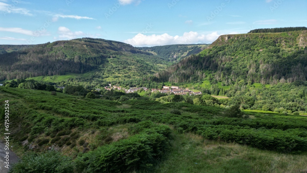 Scenic view of a town in green mountains on a sunny day