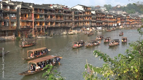 Chinese tourists sail through Fenghuang, a well preserved ancient town in central China. Many of the wooden buildings have been turned into guesthouses, hotels, and restaurants.
 photo