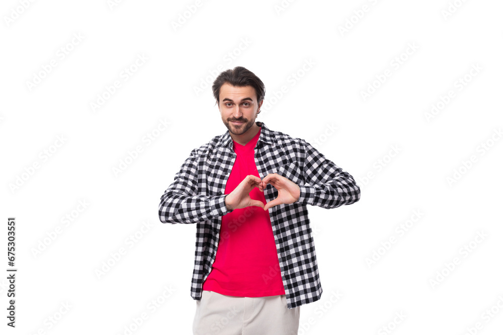 handsome pleasant young european man with black hair and beard in a shirt on a white background with copy space handsome pleasant young european man with black hair and beard in a shirt on a white background with copy space