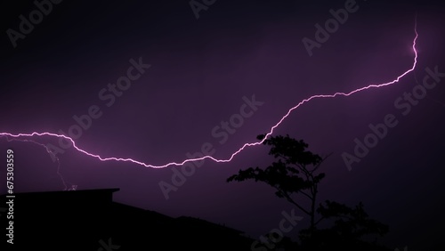 Konstfotografi Dramatic lightning flashes behind a silhouette of the trees.