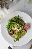 Healthy Breakfast Bowl with Oatmeal, Poached Egg, Salad and Avocado