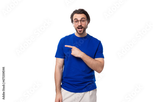 portrait of a young brunette man with a well-groomed beard dressed in a blue t-shirt on a white background with copy space