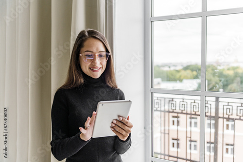 Marketer mail woman to study online for free video call uses a computer. A smart creative female designer works in an office alone writing text on a tablet.