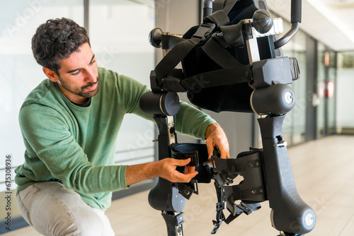 Mechanical exoskeleton engineer checking robot before delivery to customer. Physiotherapy in a modern hospital: Robotic skeleton. Physiotherapy Rehabilitation Scientists, Engineers and Physicians