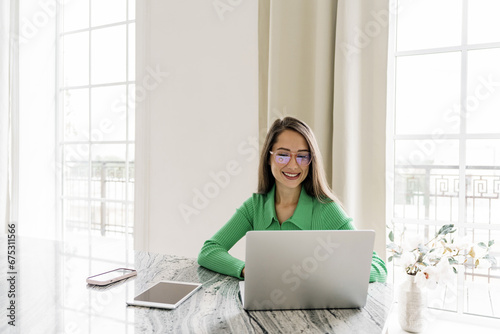 A person in the copywriter's office prints text using a computer and an online chat bot.A young female freelance designer works remotely using a laptop.