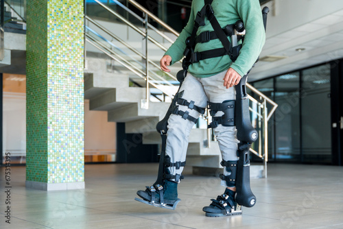 Mechanical exoskeleton, unrecognizable disabled person walking with the help of robotic skeleton, physiotherapy in a modern hospital, futuristic physiotherapy