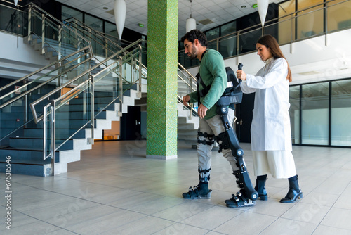Mechanical exoskeleton, female doctor physiotherapist walking with disabled person helped by robotic skeleton, physiotherapy in a modern hospital, futuristic physiotherapy