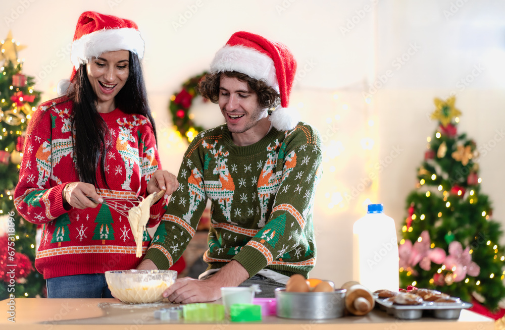 Young adult couple celebrating xmas Christmas thanksgiving in dining room kneading cake dough happy together. People enjoy celebrate Christmastime holiday with yummy good taste food and drink indoor.