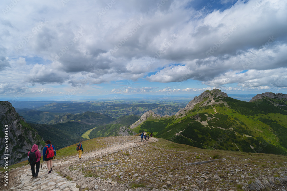 Travelers in the Polish Tatra Mountains go to the Giewont rock.