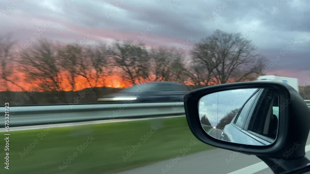 A car drives along the highway during an incredibly beautiful sunset A car drives along the highway during an incredibly beautiful sunset