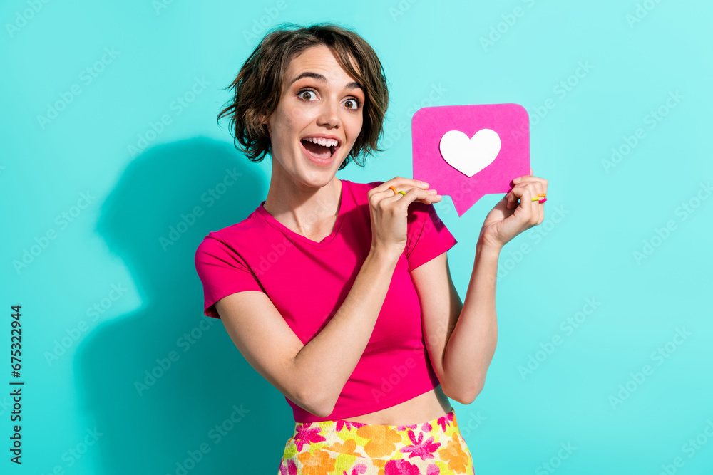 Photo of impressed nice lady open mouth arms hold paper like notification card isolated on teal color background Photo of impressed nice lady open mouth arms hold paper like notification card isolated on teal color background