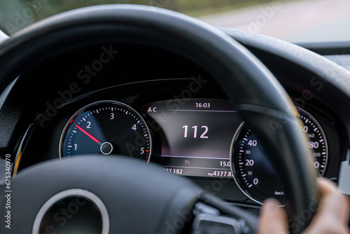 Steering wheel in a car close up, high speed driving on the road. © puhimec