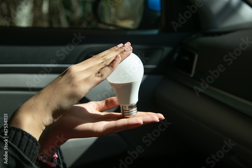 Caucasian female hand showing light bulb.