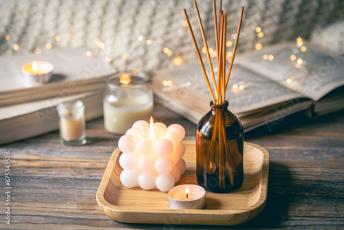 Winter spa composition with incense sticks, candles and bokeh lights. photo