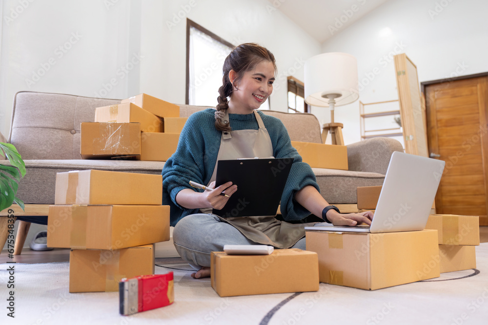 Young woman working online ecommerce shopping at her shop. Young woman seller prepare parcel box of product for deliver to customer. Online selling, ecommerce. Selling products online Young woman working online ecommerce shopping at her shop. Young woman seller prepare parcel box of product for deliver to customer. Online selling, ecommerce. Selling products online