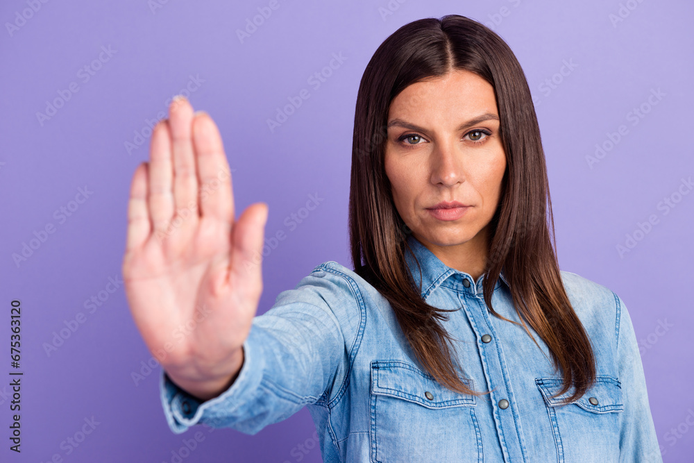 Lady making stop gesture with her palm, on a blue background
