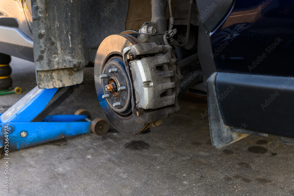 The car is raised using a hydraulic floor jack The car is raised using a hydraulic floor jack