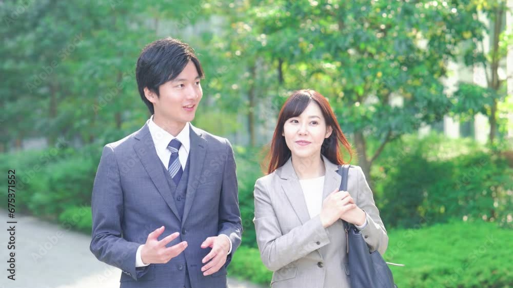 外を歩きながら話すビジネスパーソン