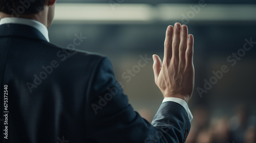 Young male politician raising his hand to swear