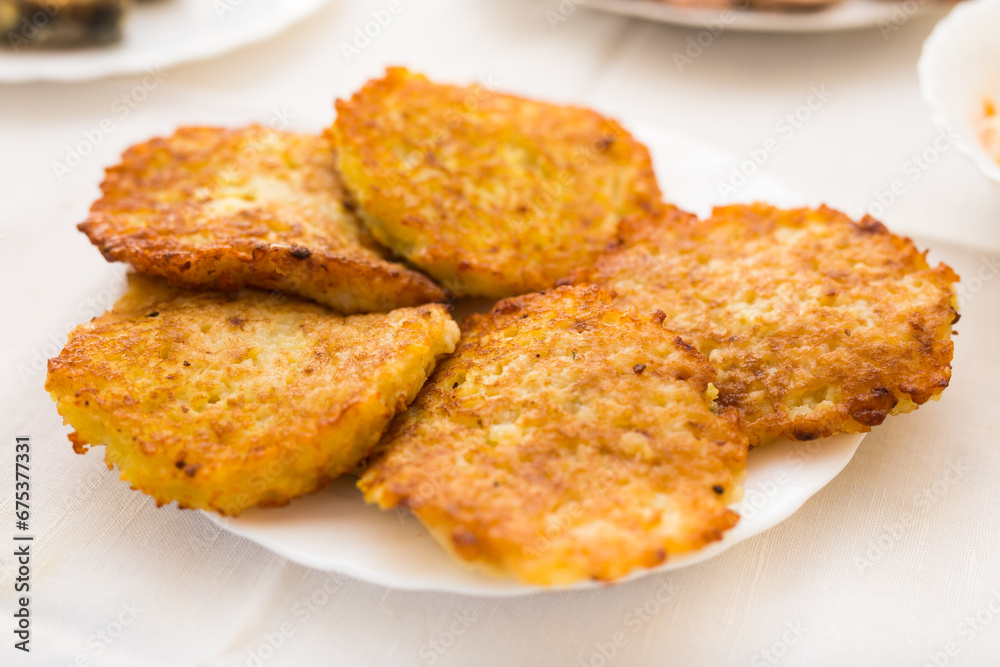 Potato pancakes with sour cream on white plate Potato pancakes with sour cream on white plate