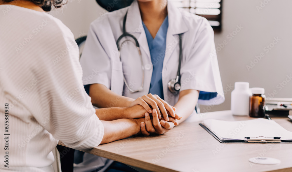 Doctor giving hope. Close up shot of young female physician leaning forward to smiling elderly lady patient holding her hand in palms. Woman caretaker in white coat supporting encouraging old person